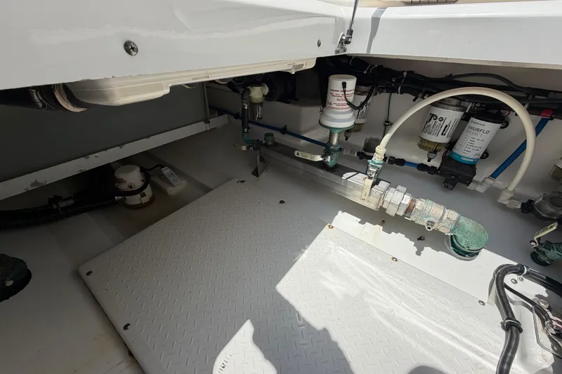 Slide: The Image of Engine compartment of a 2009 Everglades 350LX boat, showcasing plumbing and filtration systems. - 66