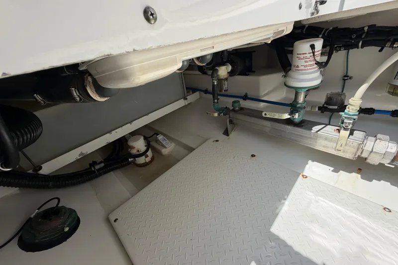 Slide: The Image of Engine compartment of a 2009 Everglades 350LX boat, showcasing mechanical components and piping. - 67
