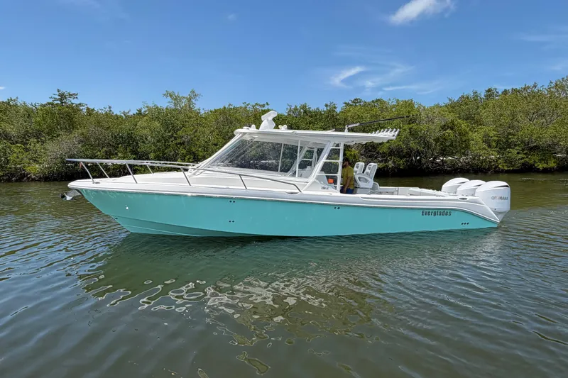 Slide: The Image of 2009 Everglades 350LX boat on calm water, surrounded by lush greenery. - 7