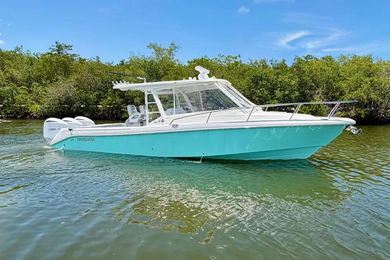 Slide: The Image of 2009 Everglades 350LX boat on calm water, surrounded by lush greenery. - 9