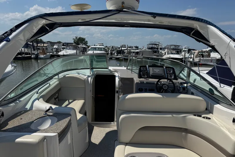Slide: The Image of 2009 Chaparral Signature 330 boat interior at marina, featuring helm and seating area. - 9