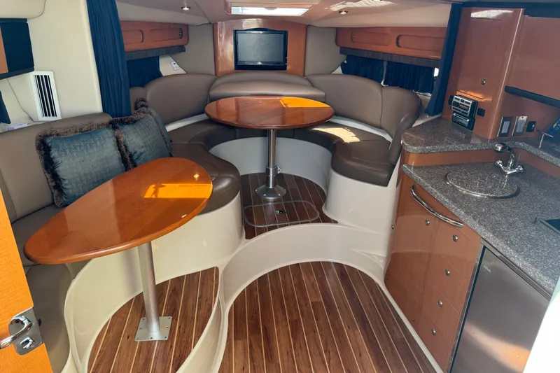 Slide: The Image of 2009 Chaparral Signature 330 interior with elegant seating, wooden tables, and modern kitchenette. - 21