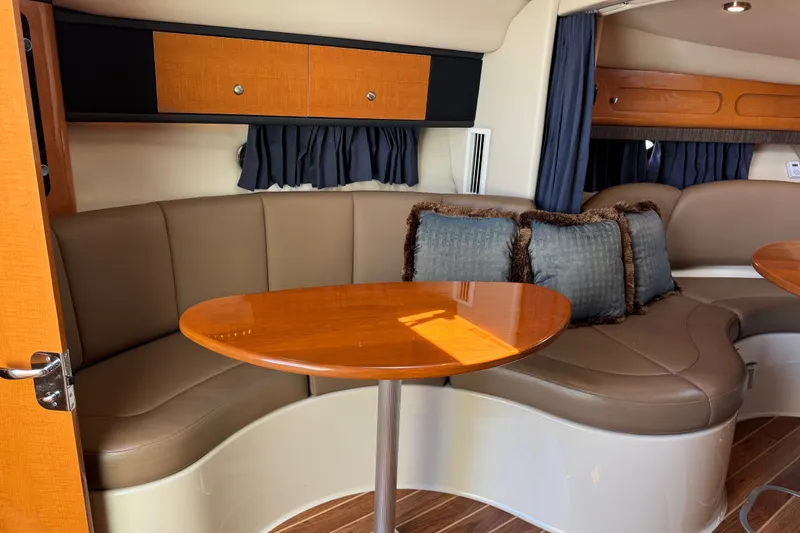 Slide: The Image of Interior of 2009 Chaparral Signature 330 yacht with curved seating and wooden table. - 23