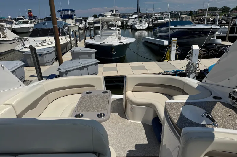 Slide: The Image of 2009 Chaparral Signature 330 yacht interior at marina, featuring plush seating and table. - 8