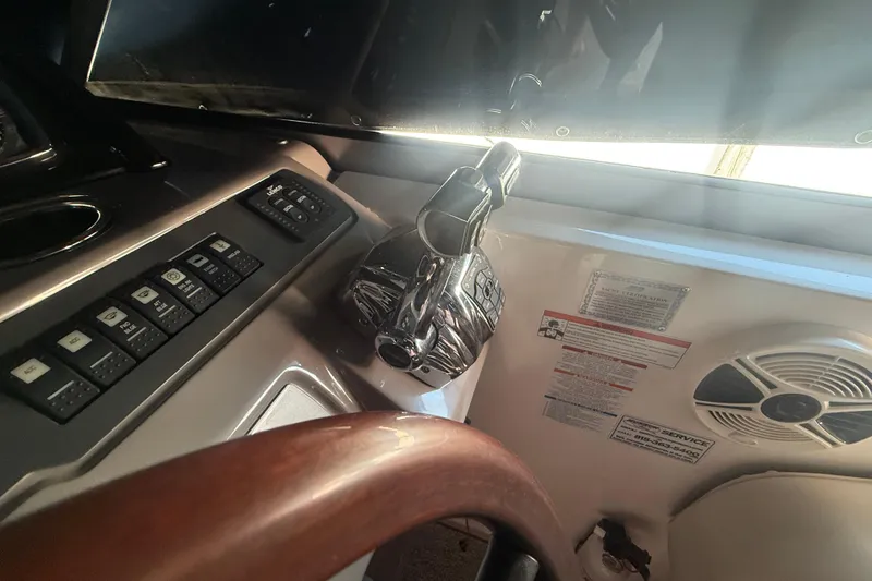 Slide: The Image of Control panel of a 2009 Chaparral Signature 330 boat with throttle and switches. - 10