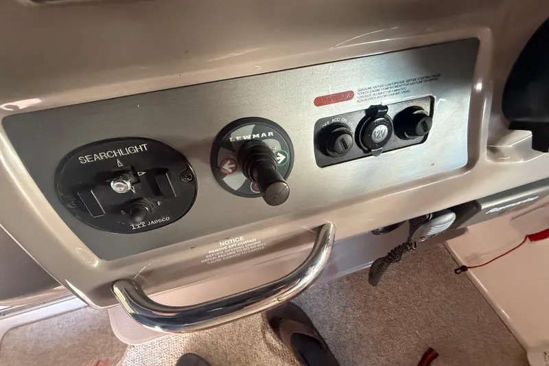 Slide: The Image of Control panel of a 2009 Chaparral Signature 330 boat featuring searchlight and power switches. - 11