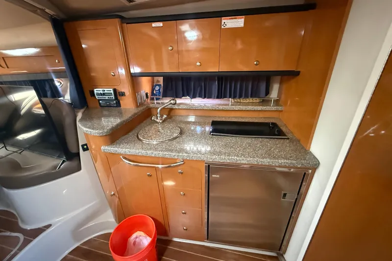 Slide: The Image of 2009 Chaparral Signature 330 yacht interior kitchen with wood cabinets and granite countertops. - 15