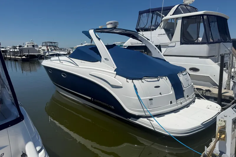 Slide: The Image of 2009 Chaparral Signature 330 boat docked at marina, covered with blue tarp. - 2