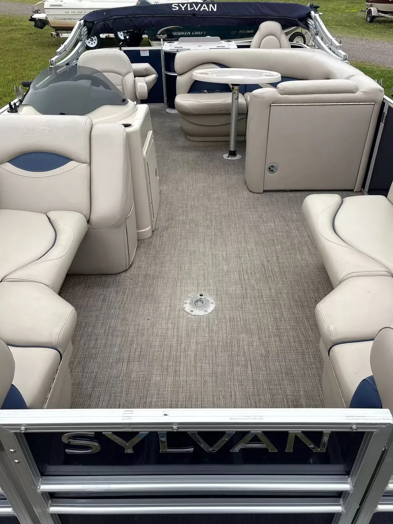 Slide: The Image of Interior of a 2016 Sylvan MIR 8520 CNF pontoon boat with beige seating and table. - 3