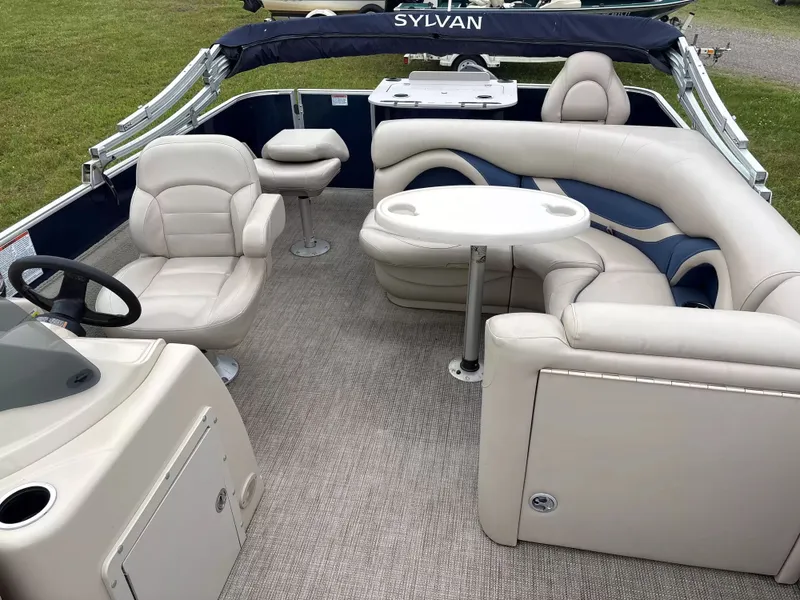 Slide: The Image of Interior of a Sylvan MIR 8520 CNF pontoon boat with beige leather seating and a table. - 4