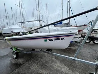 Slide: The Image of A Catalina Expo 14.2 sailboat on a trailer in a marina, surrounded by other boats. - 2