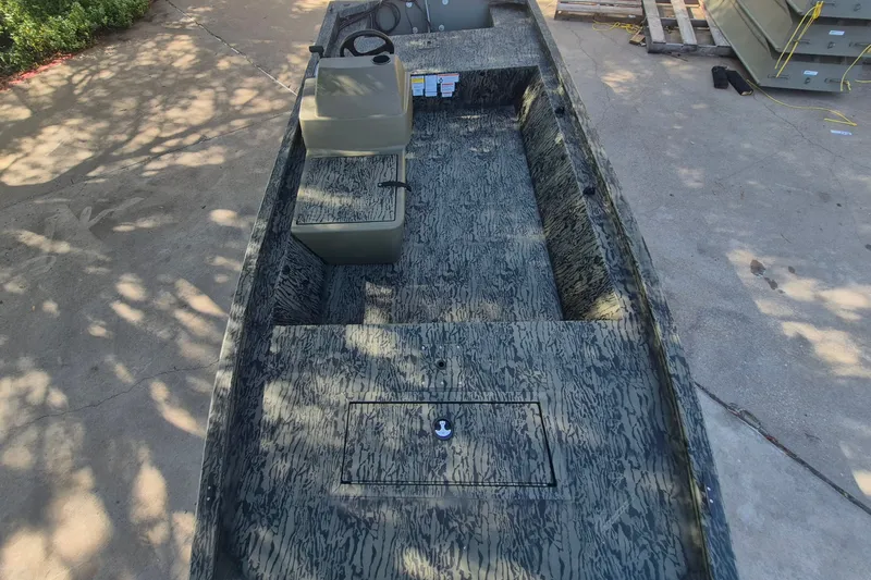 Slide: The Image of 2026 Tracker Grizzly 1648 SC boat with camouflage design, featuring seating and steering console. - 10