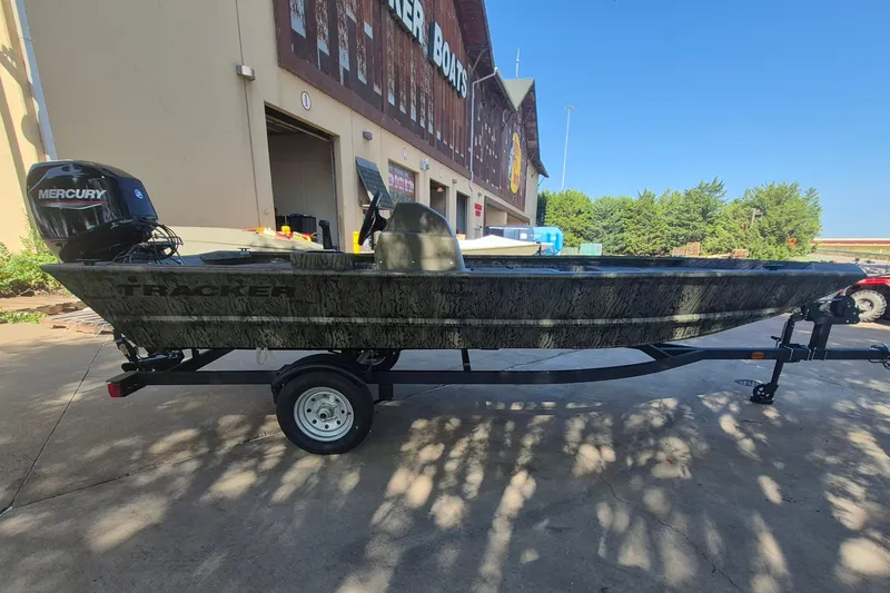 Slide: The Image of 2026 Tracker Grizzly 1648 SC boat with Mercury engine on trailer outside store. - 4