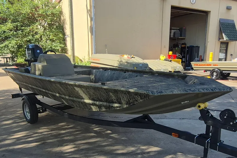 Slide: The Image of 2026 Tracker Grizzly 1648 SC boat on trailer, parked outdoors near a building. - 3