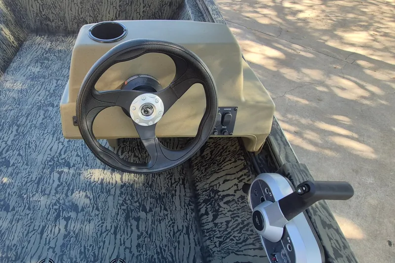Slide: The Image of Steering console of 2026 Tracker Grizzly 1648 SC boat with camouflage interior. - 8