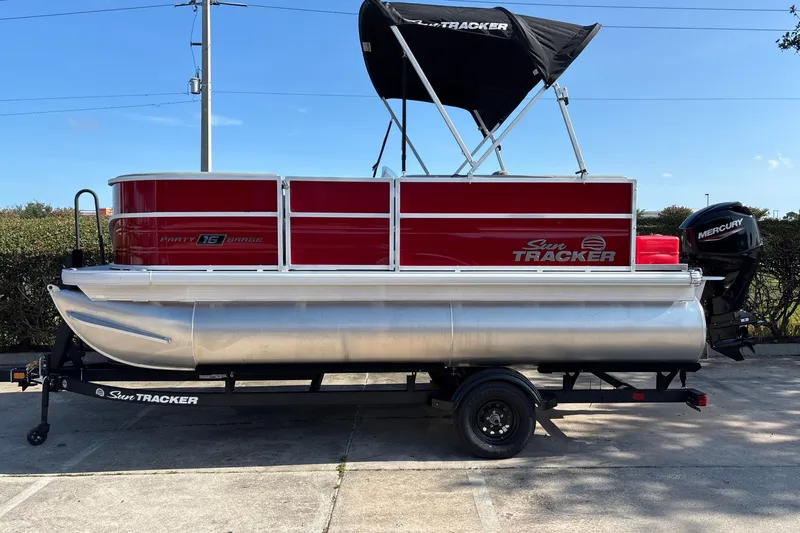 The Image of 2026 Sun Tracker Party Barge 16 DLX pontoon boat on trailer, side view. - 0