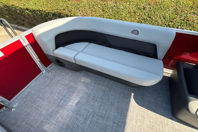 Slide: The Image of 2026 Sun Tracker Party Barge 16 DLX interior with gray seating and red accents. - 17