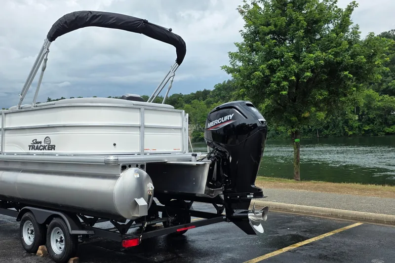 Slide: The Image of 2026 Sun Tracker Party Barge 20 DLX pontoon boat with Mercury engine by a lake. - 3