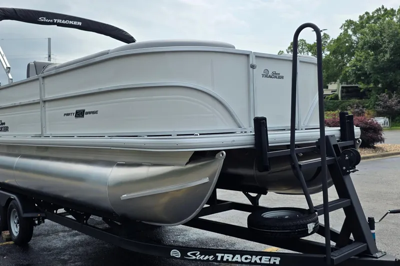 Slide: The Image of 2026 Sun Tracker Party Barge 20 DLX pontoon boat on trailer, parked outdoors. - 4