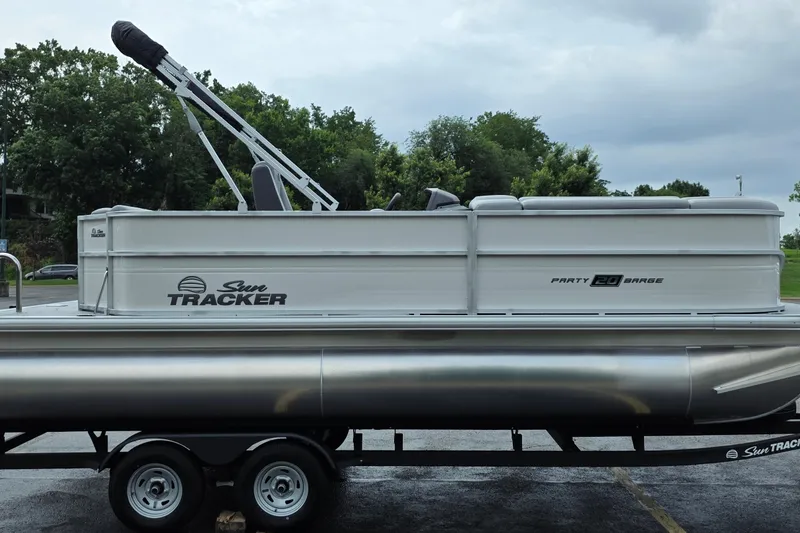 Slide: The Image of 2026 Sun Tracker Party Barge 20 DLX pontoon boat on trailer, parked outdoors. - 5