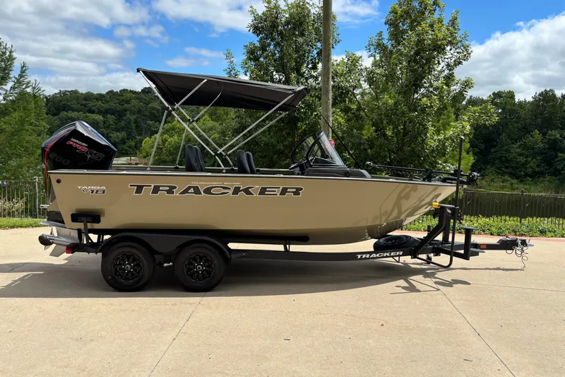 The Image of 2026 Tracker Targa V-18 Combo boat on trailer, parked outdoors with lush greenery background. - 0