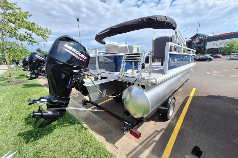 Slide: The Image of 2026 Sun Tracker Bass Buggy 18 DLX pontoon boat with Mercury engine in parking lot. - 4