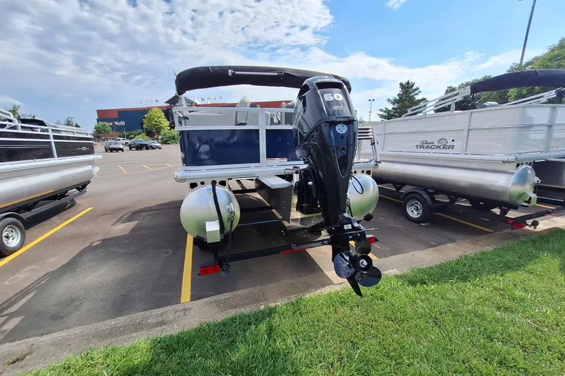 Slide: The Image of 2026 Sun Tracker Bass Buggy 18 DLX pontoon boat with 60 HP engine in parking lot. - 5