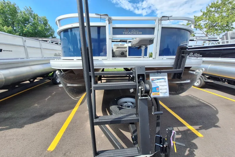 Slide: The Image of 2026 Sun Tracker Bass Buggy 18 DLX pontoon boat on trailer in parking lot. - 6