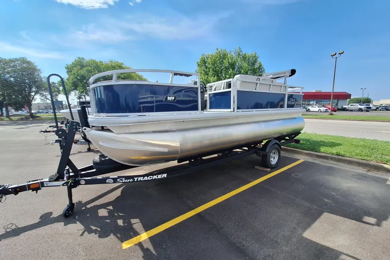 Slide: The Image of 2026 Sun Tracker Bass Buggy 18 DLX pontoon boat on trailer in parking lot. - 7