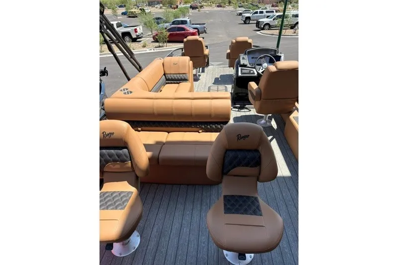 Slide: The Image of Interior of 2026 Ranger 223F boat with tan and black seating, parked in a lot. - 3