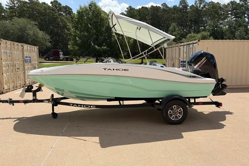 Slide: The Image of 2026 Tahoe T16 boat with canopy on trailer, parked outdoors. - 4