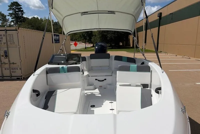 Slide: The Image of 2026 Tahoe T16 boat interior with canopy, parked outdoors. - 2