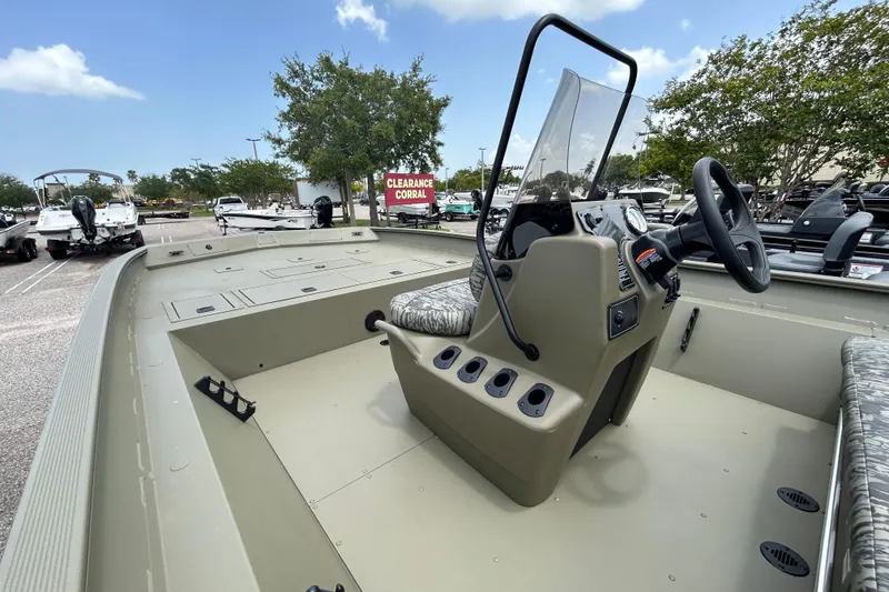Slide: The Image of 2026 Tracker Grizzly 2072 CC boat interior with steering console, parked outdoors. - 4