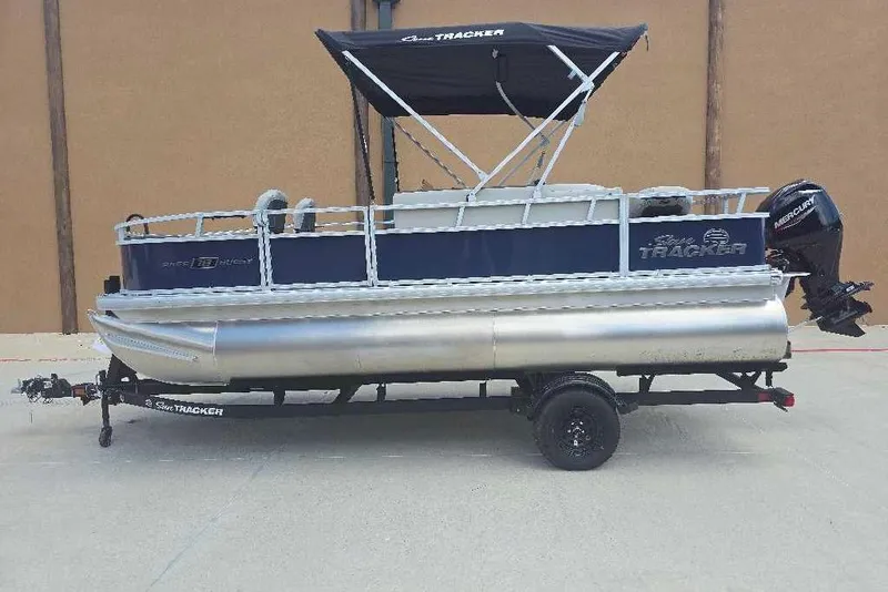 Slide: The Image of 2026 Sun Tracker Bass Buggy 18 DLX pontoon boat on trailer, side view. - 3