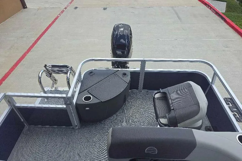 Slide: The Image of 2026 Sun Tracker Bass Buggy 18 DLX pontoon boat interior with seating and motor view. - 7