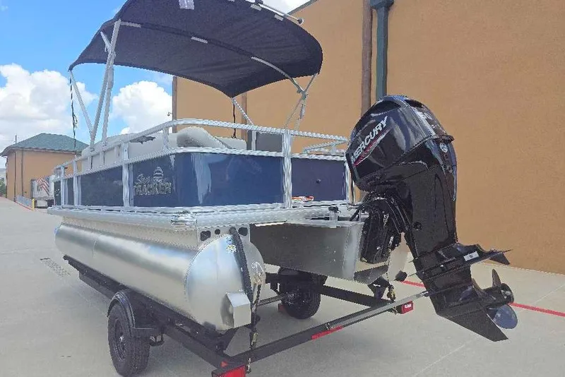 Slide: The Image of 2026 Sun Tracker Bass Buggy 18 DLX pontoon boat with Mercury outboard motor on trailer. - 2