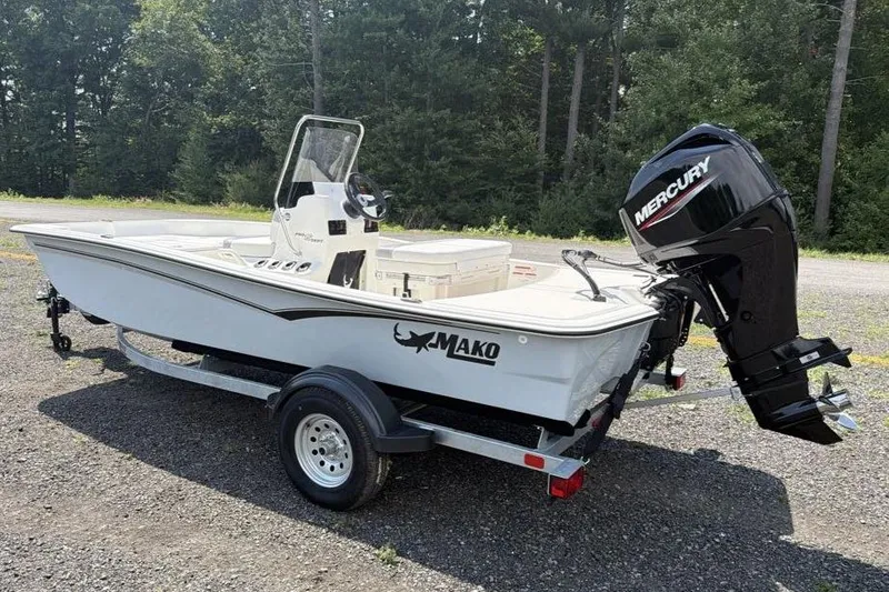 Slide: The Image of 2026 Mako Pro Skiff 15 CC boat with Mercury engine on trailer, parked outdoors. - 4