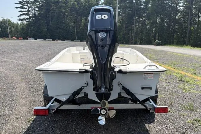 Slide: The Image of 2026 Mako Pro Skiff 15 CC boat with 50 HP engine, parked on gravel. - 7