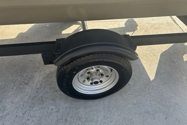 Slide: The Image of Trailer wheel of 2026 Tracker Grizzly 1648 SC on concrete surface. - 2
