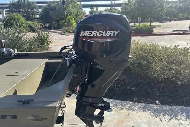 Slide: The Image of 2026 Tracker Grizzly 1648 SC boat with Mercury outboard motor in a sunny outdoor setting. - 11