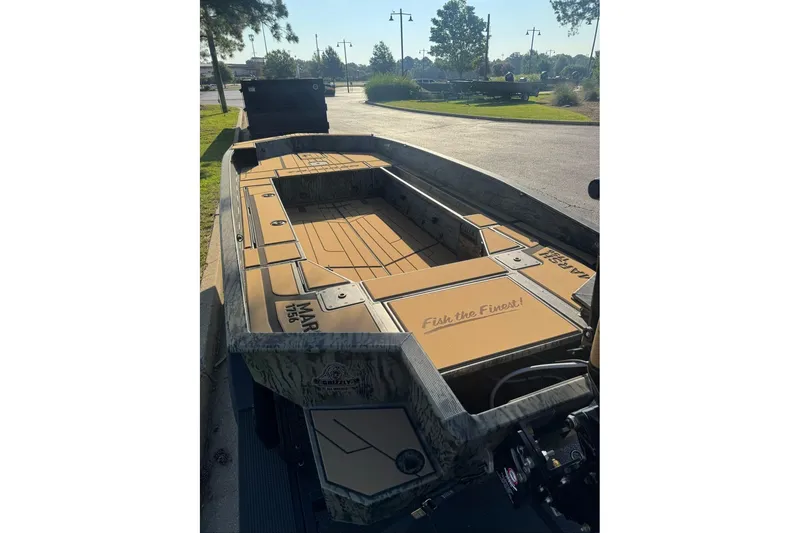Slide: The Image of 2026 Tracker Grizzly 1756 T Marsh boat, parked outdoors, showcasing spacious interior design. - 5