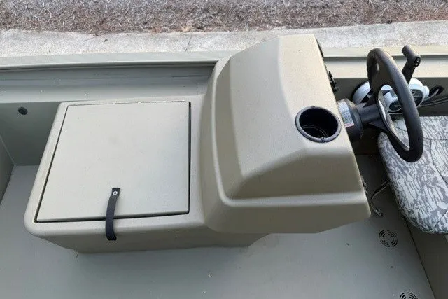 Slide: The Image of 2026 Tracker Grizzly 1754 SC boat console with steering wheel and storage compartment. - 8