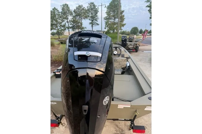 Slide: The Image of 2026 Tracker Grizzly 1754 SC boat with Mercury 75 outboard motor, parked outdoors. - 4