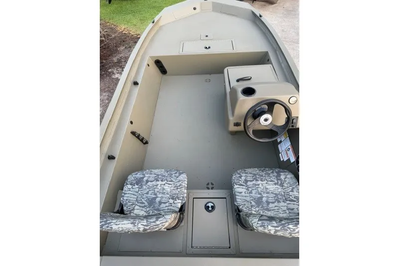 Slide: The Image of 2026 Tracker Grizzly 1754 SC boat interior with camo seats and steering console. - 12