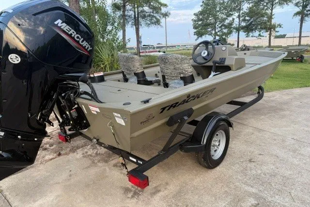 Slide: The Image of 2026 Tracker Grizzly 1754 SC boat with Mercury engine on trailer, parked outdoors. - 2