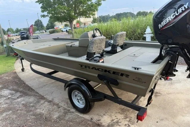 Slide: The Image of 2026 Tracker Grizzly 1754 SC boat with Mercury engine on trailer, parked outdoors. - 3