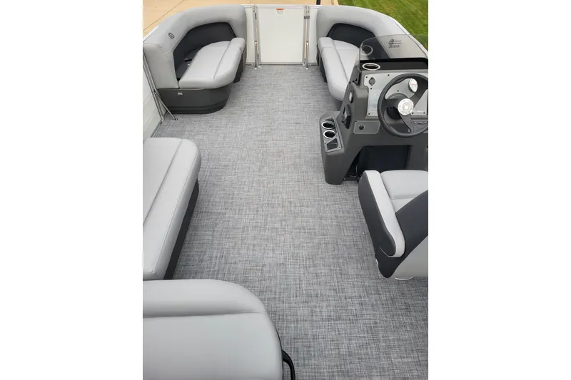 Slide: The Image of 2026 Sun Tracker Party Barge 16 DLX interior with gray seating and steering console. - 3