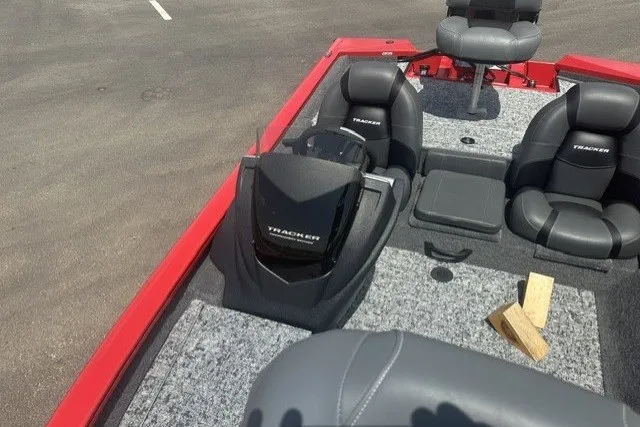 Slide: The Image of 2026 Tracker Pro Team 175 boat interior with seating and motor, parked on pavement. - 18
