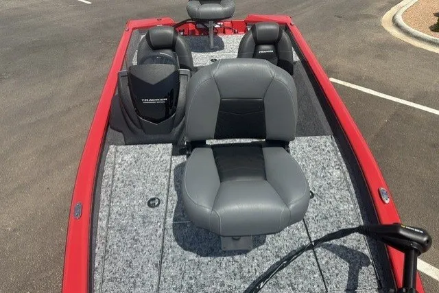Slide: The Image of 2026 Tracker Pro Team 175 boat with gray seating and red trim, parked on pavement. - 13