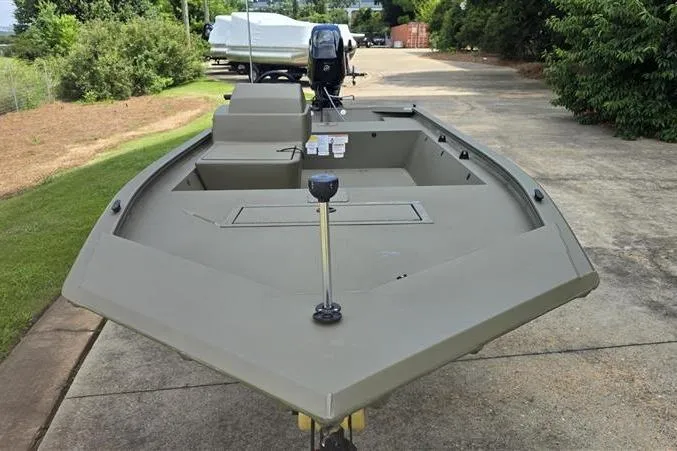 Slide: The Image of 2026 Tracker Grizzly 1648 SC boat on a driveway, featuring a sleek, open deck design. - 5